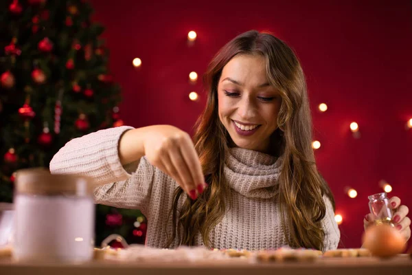 Bastante morena de pelo largo chica decoración recién horneado galletas de Navidad — Foto de Stock