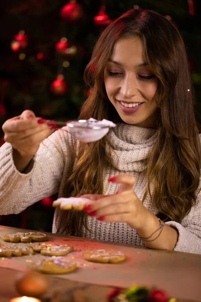 Horneado de Navidad. bonita mujer joven decorando galletas de jengibre de Navidad — Foto de Stock