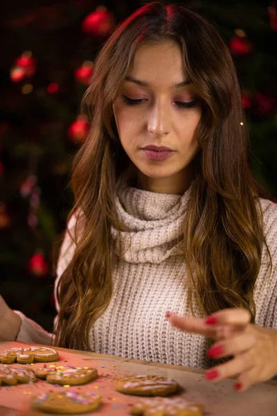 Panadería de Navidad. Pensativo chica triste decorar galletas de jengibre de Navidad — Foto de Stock