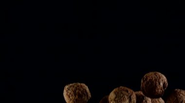 Ağır çekimde kakao tozu bulutu içinde uçan siyah çikolatalı mantarlar.