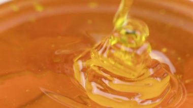 Organik arı balı ağır çekimde akıyor, sağlıklı doğal şekerler.