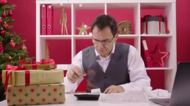 Tatil krizi konsepti. Adam umutsuzca cellatların kırmızı süslemelerine bakıyor.