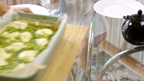La mujer de cerca pone en la mesa quiche de espinacas recién horneadas, cena familiar — Vídeo de stock