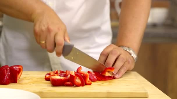 Omul de aproape taie piperul roșu proaspăt în felii de gătit mâncare vegetariană sănătoasă — Videoclip de stoc