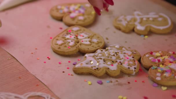 Frisch gebackene Lebkuchen beim Weihnachtsbacken mit Goldsternen dekorieren — Stockvideo