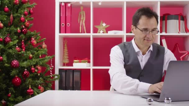 I regali online cadono sulla tavola all'ufficio decorato di Natale dopo entrano spingendo — Video Stock