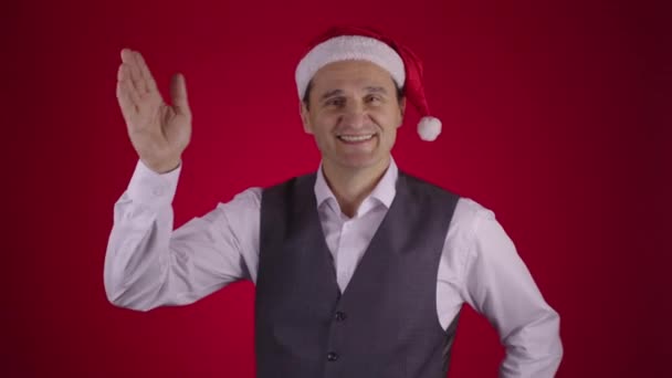 Feliz emocionado hombre de 40 años en Santa sombrero captura volando caja de regalo y muestra el pulgar hacia arriba — Vídeos de Stock