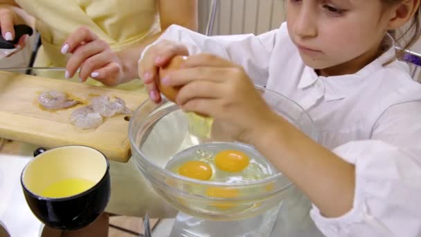 Pequeno ajudante cozinhar com a mãe, menina quebra ovos em tigela. Crianças simples refeições — Vídeo de Stock