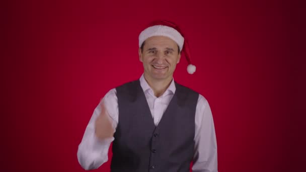 Christmas wreath flies into frame and falls on neck happy 40s man in Santa hat — Stock Video