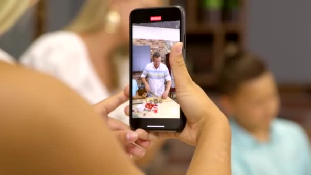 Jong meisje voedsel blogger filmen op telefoon familie diner koken. Huisgemaakte gerechten — Stockvideo