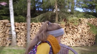 Kız ateşte kızartmak için bir dilim ekmeği şişin üzerine koyar. Yakacak odunların arka planı