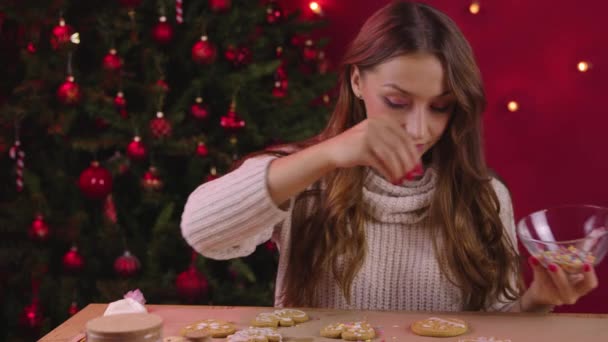Christmas baking. Pretty woman decorate gingerbread cookies with sugar sprinkles — Stock Video