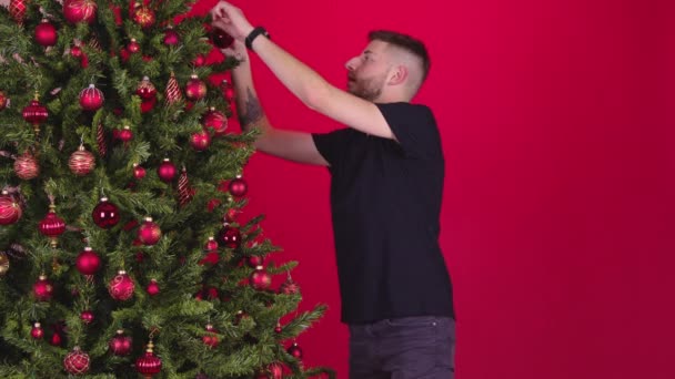 Junges schwules Paar hängt Dekorationen am Weihnachtsbaum zusammen — Stockvideo