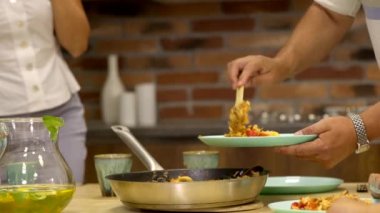 Evde yemek pişirme: erkeğin eli iştah açıcı, lezzetli paella tabağında.