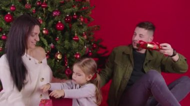 Güzel bir aile Noel ağacının yanında Noel hediyeleri veriyor, sihirli tatil anları.