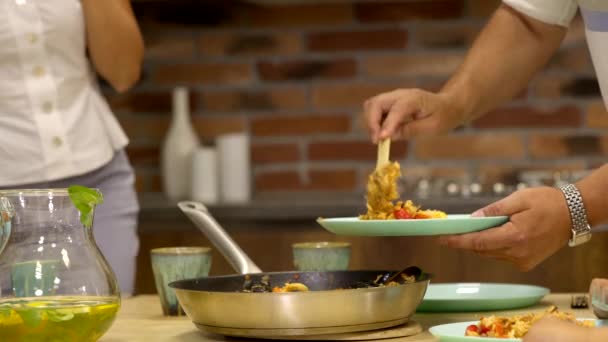 Koken thuis: mans hand legt smakelijke heerlijke paella op bord — Stockvideo