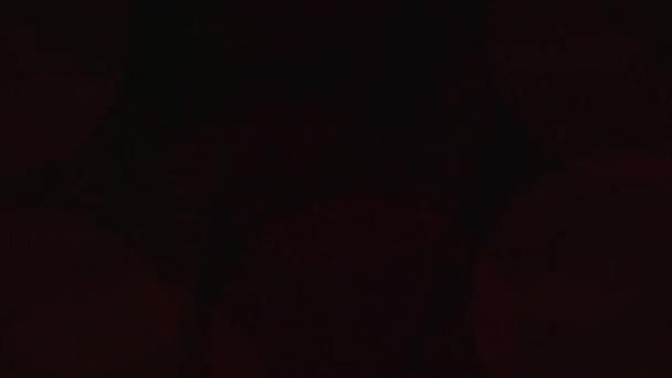 Zářivý bokeh z věnce na tmavém pozadí. Nový rok nebo vánoční pozadí — Stock video