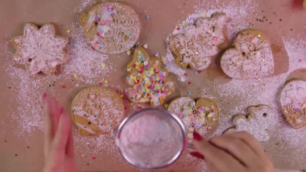 크리스마스 쿠키에는 여성 손으로 설탕 가루를 뿌리고 위를 바라본다 — 비디오