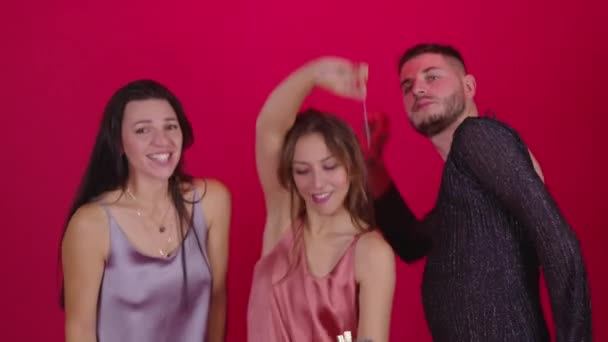 Zwei Frauen und ein schwuler Transvestit tanzen auf rotem Hintergrund. Hennen-Partei LGBTQ — Stockvideo