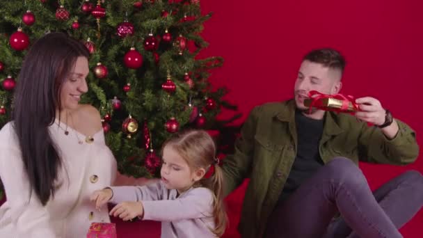 Bela família dando presentes de Natal perto da árvore de xmas, momentos mágicos de férias — Vídeo de Stock