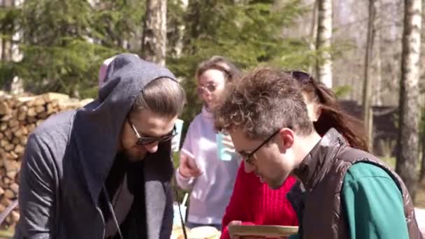 Mężczyźni grillują pstrągi na pikniku. Kobieta lubi aromat grillowanego jedzenia. — Wideo stockowe