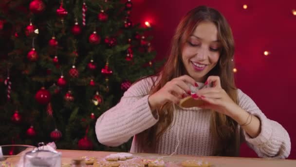 Jovem mulher bonita fazendo decoração de biscoitos xmas para o jantar de família de Ano Novo — Vídeo de Stock