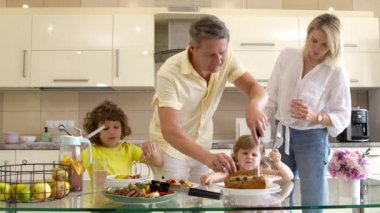 Mutlu güzel aile yemeği servis ediyor, aileler küçük çocuklara lezzetli yemekler yapıyor.