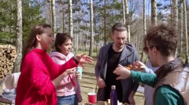 Bir grup neşeli genç yaz pikniğinin tadını çıkarıyor, barbekü partisi.