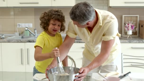Ayah yang bahagia dan putra rambut keriting yang lucu memasak bersama mengaduk adonan dengan kocokan — Stok Video
