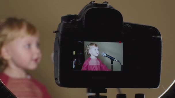 Nettes kleines Mädchen singt Lied ins Mikrofon, lustiges Kleinkind genießt die Sendung — Stockvideo