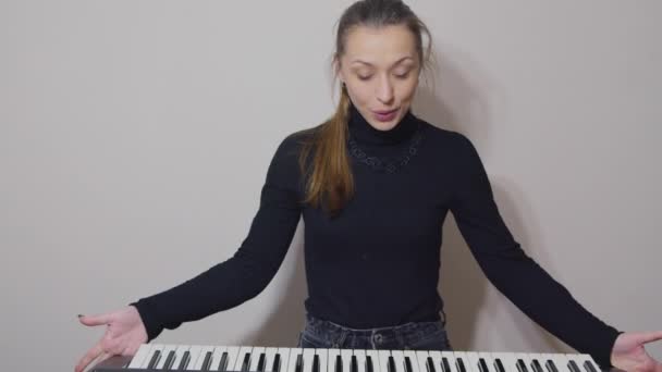 Blogueiro positivo gravação ensino vlog vídeo sobre jogar no sintetizador — Vídeo de Stock