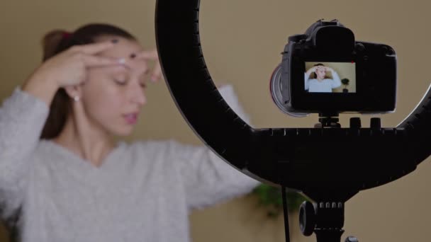 Jovem blogueira fazendo exercícios de condicionamento facial em casa, transmissão ao vivo — Vídeo de Stock