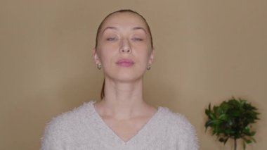 Genç bayan blogcu evde yüz egzersizi yapıyor, canlı yayın yapıyor.