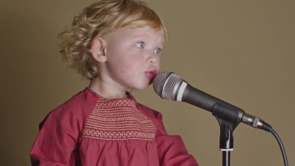 Nettes kleines Mädchen singt Lied ins Mikrofon, lustiges Kleinkind genießt die Sendung — Stockvideo
