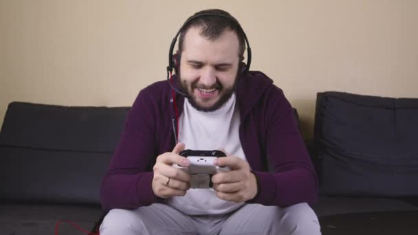 Jogador masculino feliz com fone de ouvido jogar videogame online segurando joystick, streaming — Vídeo de Stock