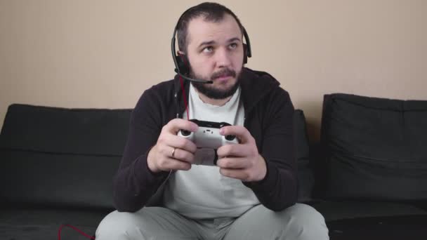 Joueur sérieux avec casque et joystick participer à la compétition de jeux en ligne — Video