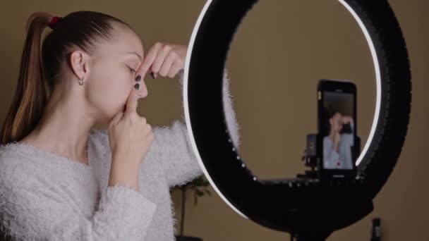 Młoda blogerka ćwicząca jogę twarzy, rzeźbiąca strefę nosa, streaming na żywo — Wideo stockowe