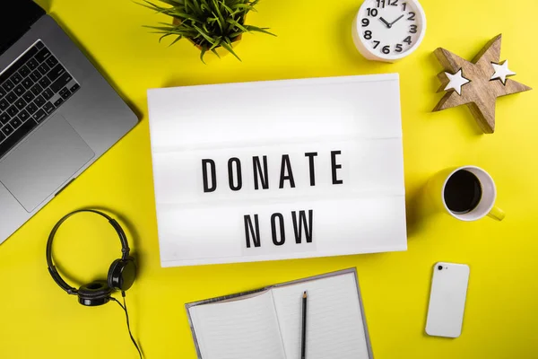 Donate Now message on lightbox on modern yellow office desktop with laptop — Stock Photo, Image