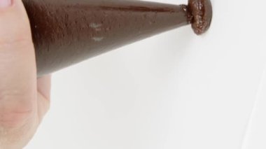 Dikey çekim kapanış şekerlemecisi hamur torbasından ganache kreması sıkar, yer mantarı yapar