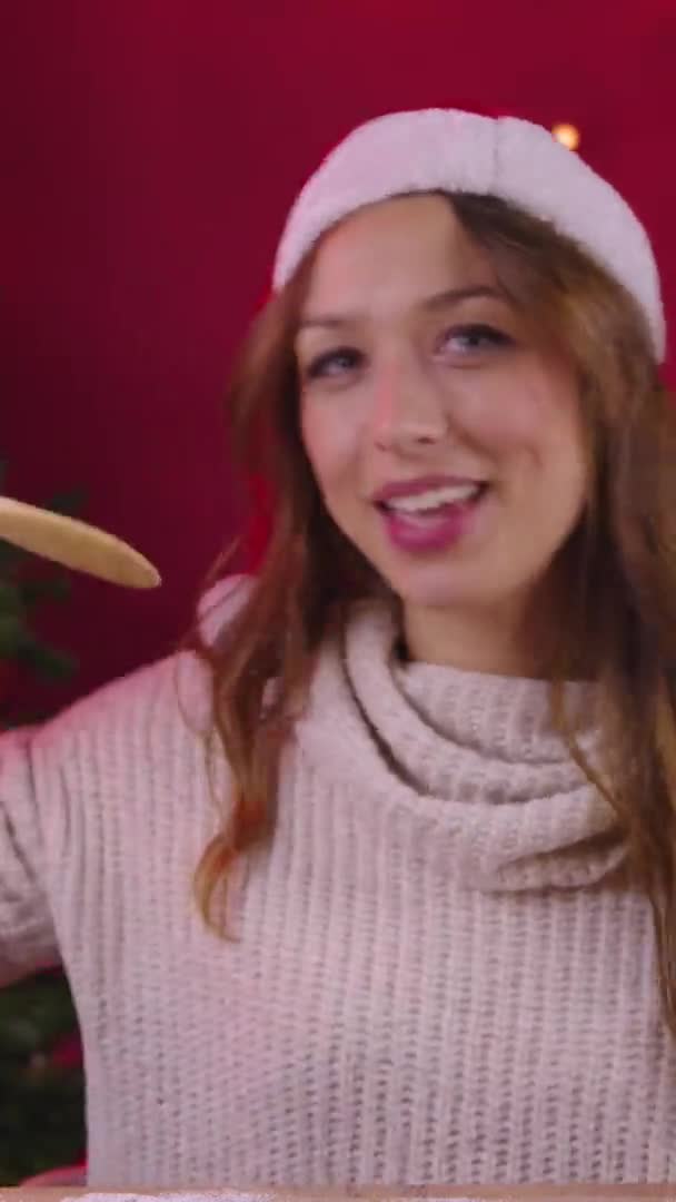 Tiro vertical Linda chica cantando con espátula de madera en lugar de micrófono en la decoración de Navidad — Vídeo de stock