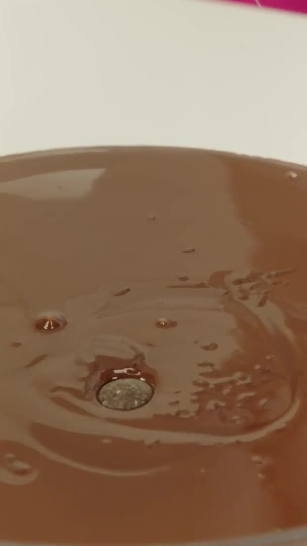 Colpo verticale Primo piano versando gocce di cioccolato nel cioccolato fondente in una ciotola di vetro — Video Stock