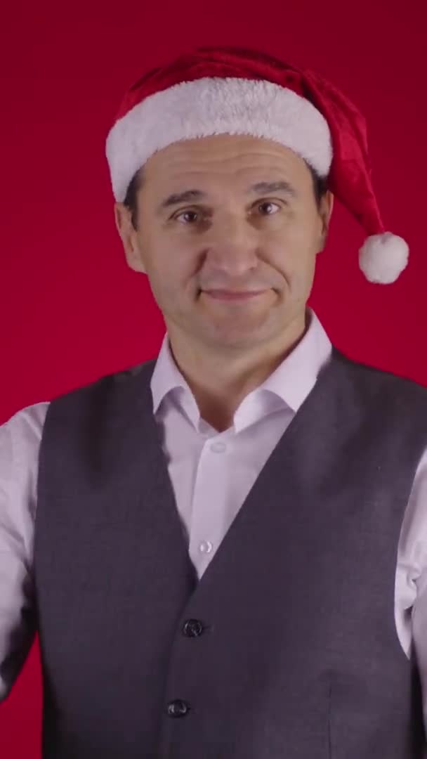 El hombre alegre en el sombrero de Santa señalando el reloj recuerda Minutos antes de Nochevieja — Vídeos de Stock