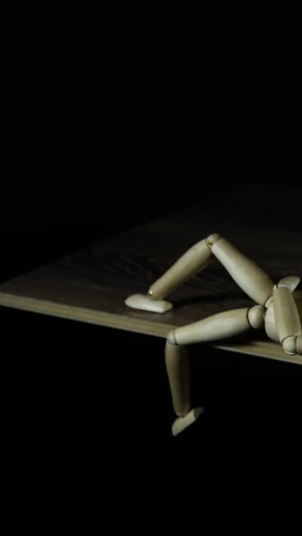 Вертикальне відео Зупинка дерев'яної фігури манекенні прокрастинати в студії на чорному фоні кладки і махаючі ноги — стокове відео