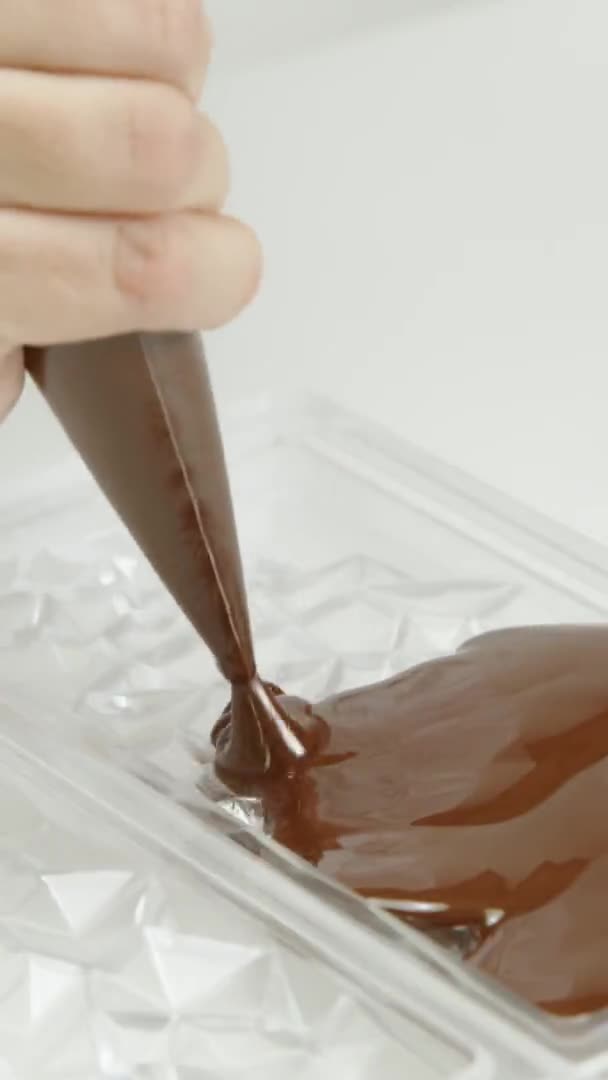 Disparo vertical Primer plano verter chocolate negro en el molde en forma de diamante de la barra, cámara lenta — Vídeos de Stock