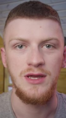 Dikey çekim, kendine güvenen kızıl saçlı vlogger, kamera konuşmasına bilgisayar uygulaması web kamerası görüntüsü kullanarak bak