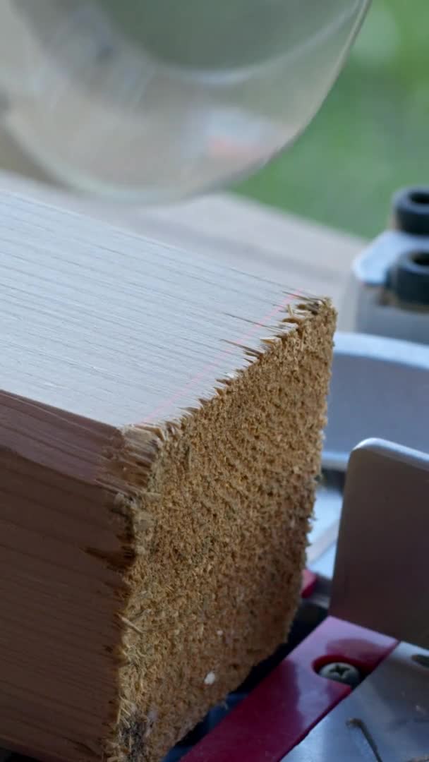 Tiro vertical Proyecto de bricolaje carpintero con guantes corta poste de madera 4x4 en la sierra de mitra de cerca — Vídeos de Stock