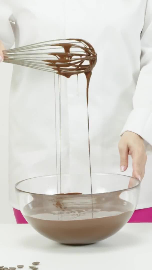 Verticaal schot Mengen van heerlijk gesmolten pure chocolade met garde in glazen kom. Sluitingsdatum — Stockvideo