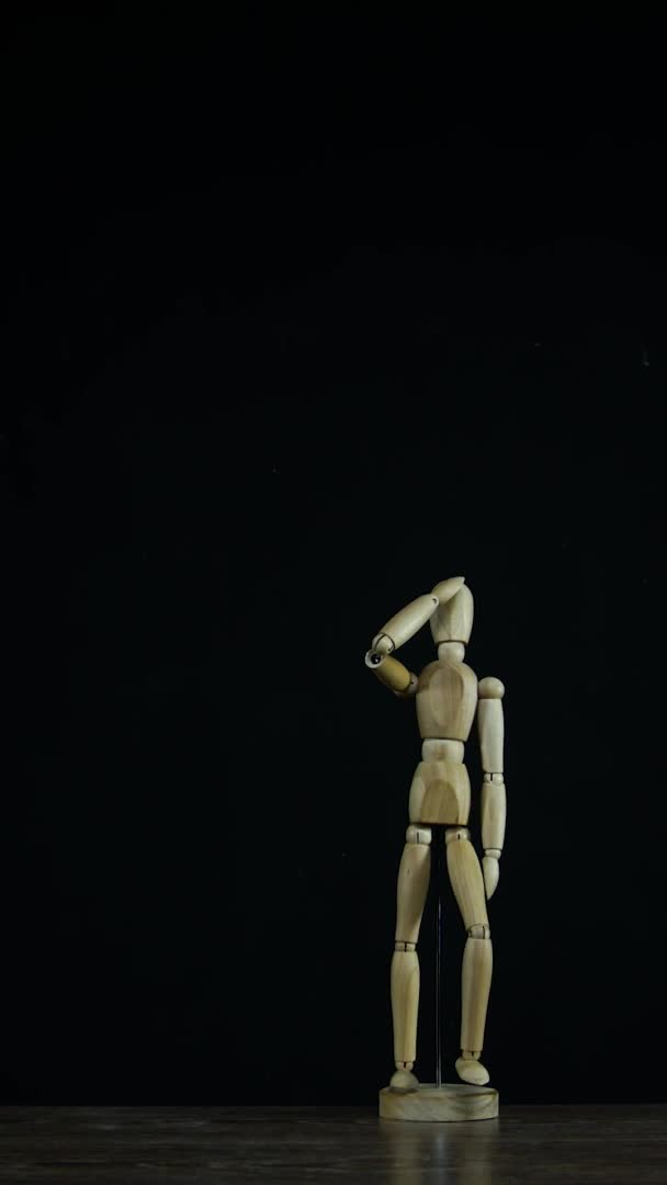 Вертикальне відео Зупинка дерев'яної фігури манекен в студії на чорному фоні марші — стокове відео