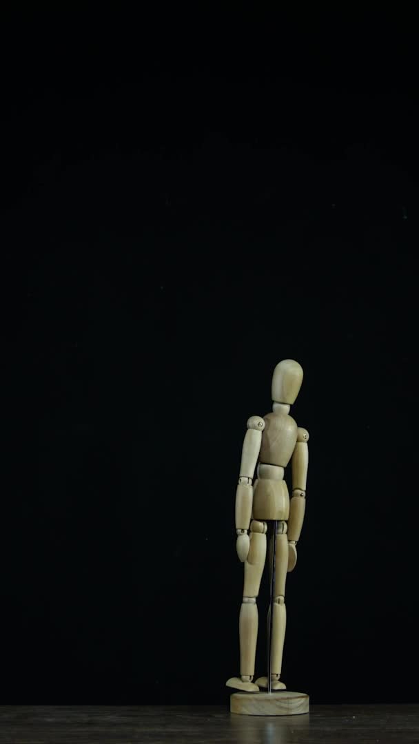 Vídeo vertical Stopmotion boneco figura de madeira em estúdio sobre fundo preto fica e gira — Vídeo de Stock