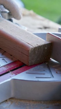 Dikey çekim marangozu Mitre 'yi 30 derece kesiyor ve ahşap işi çapraz kesiyor.